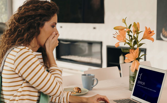 chica sorprendida mirando mensaje de error en la pantalla del ordenador