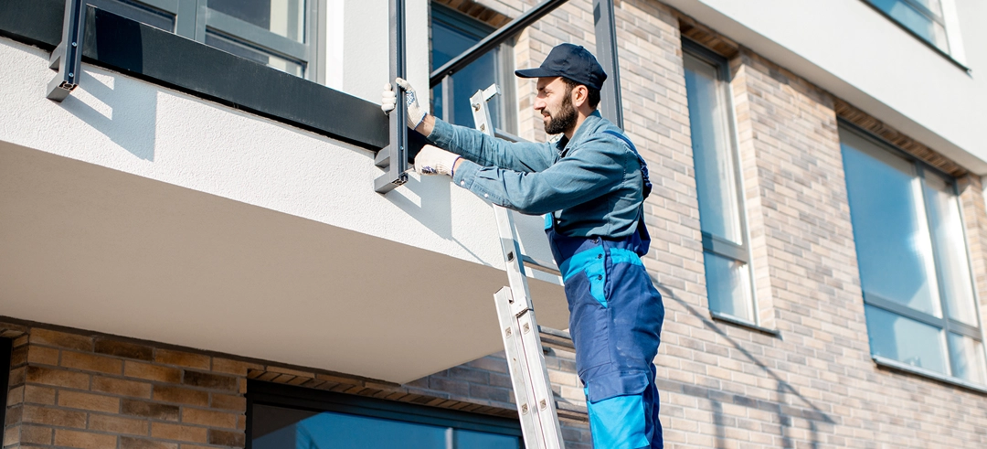 Obrero reparando la barandilla de un balcón