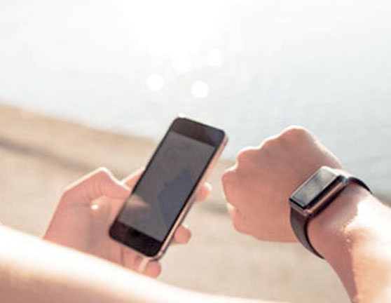 Mujer antes de correr sincronizando el móvil con su smart watch