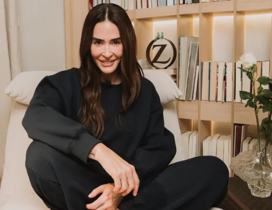 Vicky Martín Berrocal sentada junto a la librería de su casa.